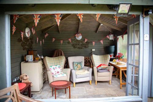 Cornwall House Summer House with cosy decor, chairs and bunting.