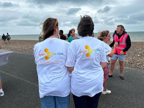 Beehive Care staff at Worthing Pride showing their custom pride at the hive logo on tshirts