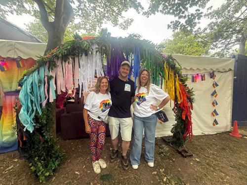 Beehive Care staff at Worthing Pride taking photos under a rainbow arch